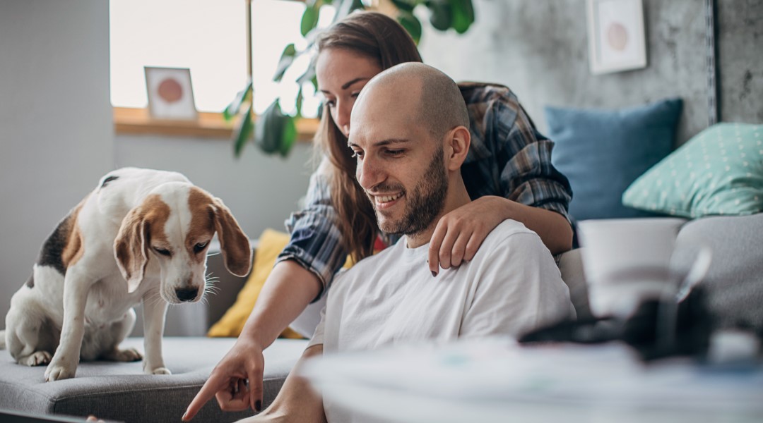 Couple on laptop with dog